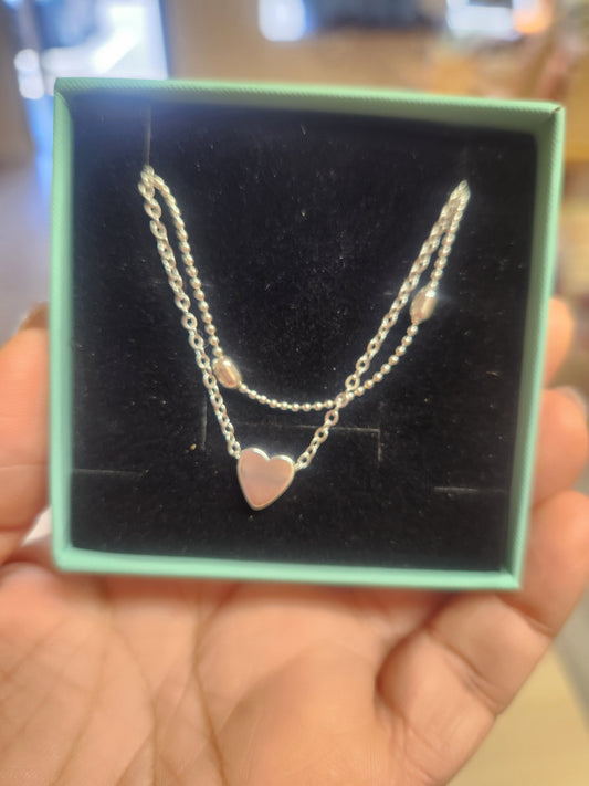 Silver double ankle bracelet with heart pendant.